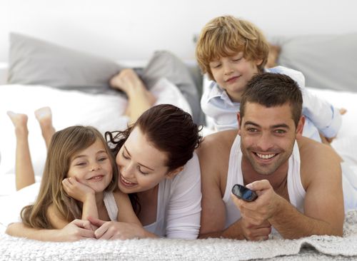 family_with_remote_on_bed